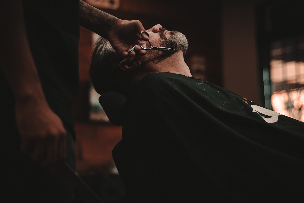 Barber shaving a client in a barbershop