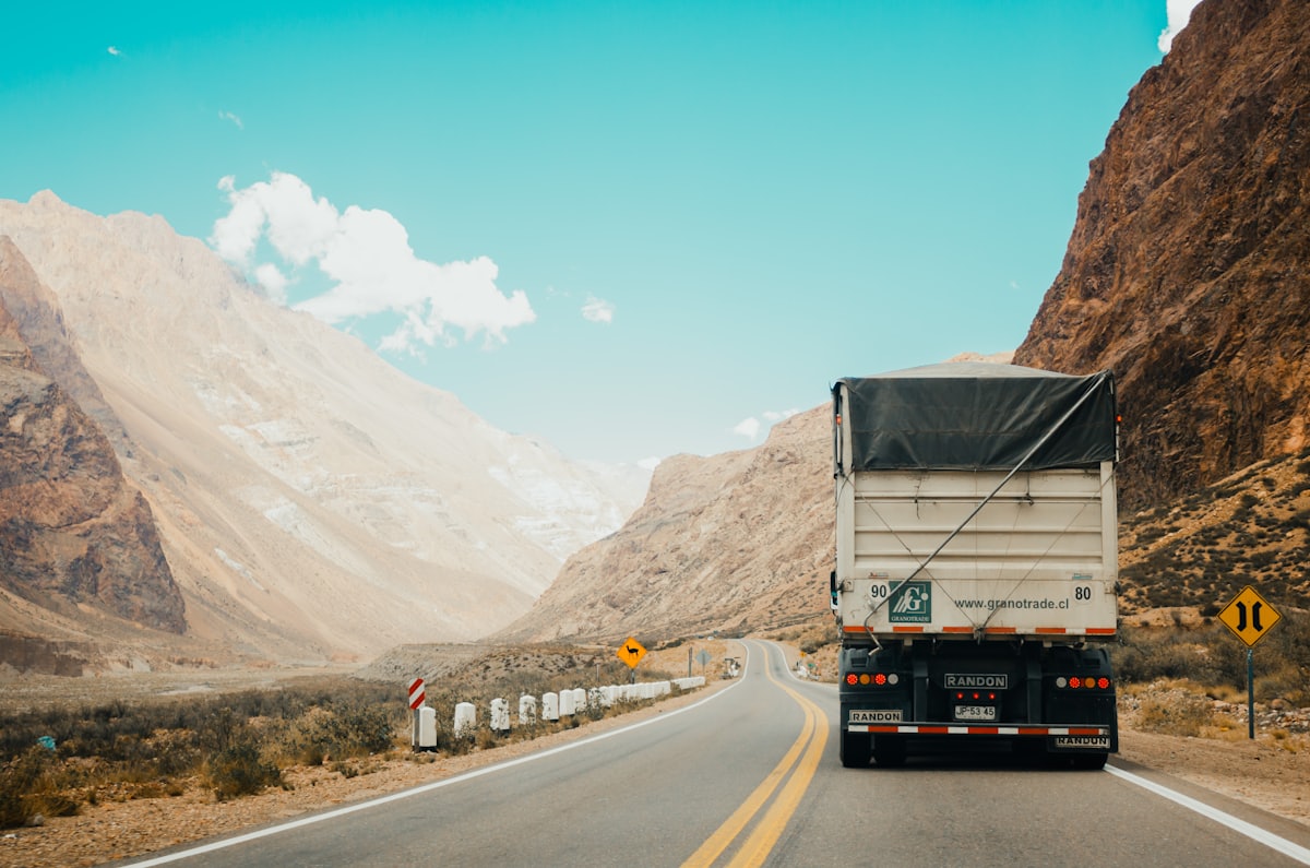 Lorry on an open road through hills