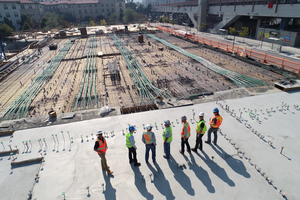 Construction workers on a concrete slab reviewing a build